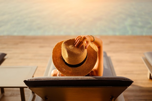 Vrouwen slapen en rusten in de zomer aan het zwembad van een hotel.