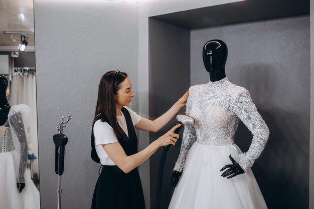 Vrouwen strijken trouwjurk in studio door Strijkmachine Wedding concept