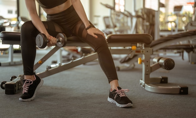 Vrouwen trainen met dumbbells in de indoor gym voor een goede gezondheid bij zonsondergang Fitness workout