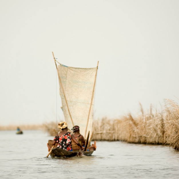 Vrouwen varen op de lagune van het paaldorp Ganvie in Benin.