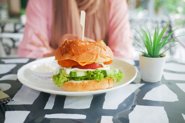 Vrouwen wachten op het eten van hamburger op tafel