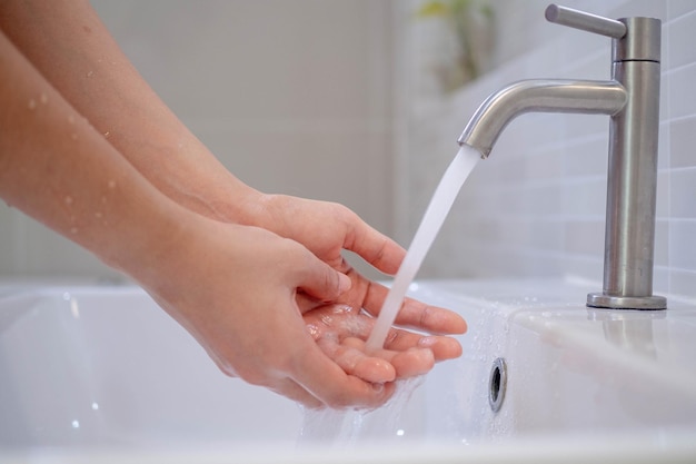 Vrouwen wassen handen met schoon water Was je handen om ze schoon te houden en de verspreiding van virussen te voorkomen