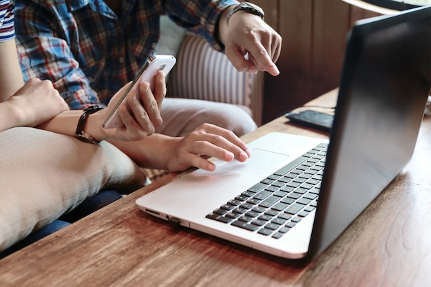 Vrouwen wat betreft het scherm en man het typen laptop op houten lijst