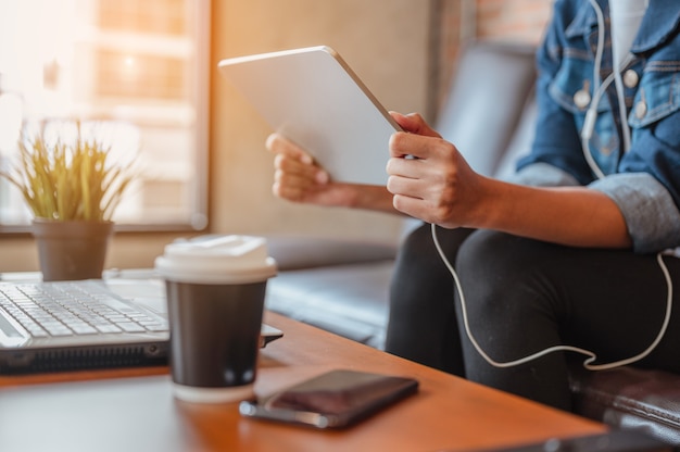 Vrouwen zijn ontspannen tijdens het kijken of winkelen op labtop tijdens de koffiepauze na het werk in de coffeeshop