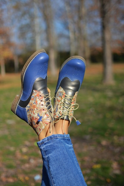 Vrouwenbenen met schoenen met bindende schoenveters in het park