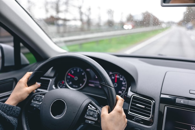 Vrouwenbestuurders handen op het stuur van een auto