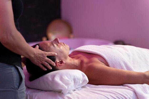 Vrouwenfysiotherapeut die een massage doet aan een andere vrouw in haar hoofd