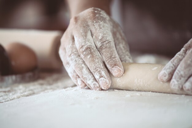 Vrouwenhand die brooddeeg voor bakselkoekjes voorbereiden in de keuken