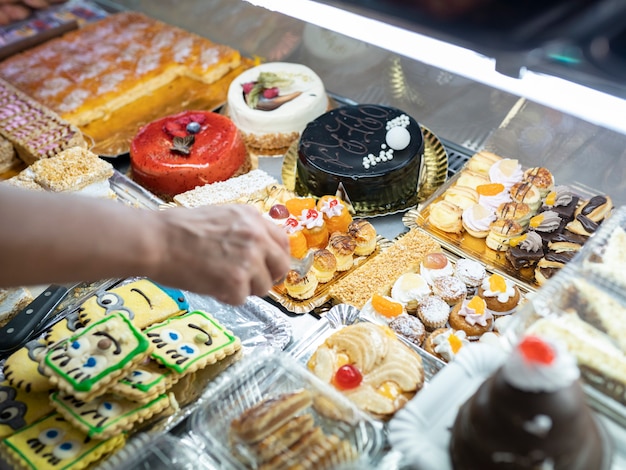 Vrouwenhand die cake neemt in een banketbakkerij