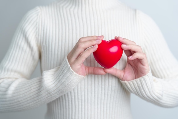 Vrouwenhand die de rode hartvorm houden van de liefdedonor wereldhartdag wereldgezondheidsdag en verzekeringsconcepten