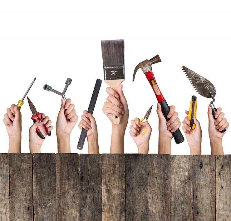 Foto vrouwenhand die die een inzameling van diy-hulpmiddelen houden met houten worden geplaatst op wit worden geïsoleerd