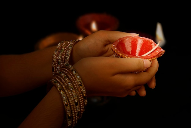 Vrouwenhand die diya-olielampen voor het diwali-festival houdt