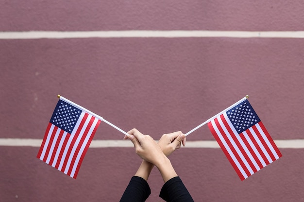 Foto vrouwenhand die een kleine patriottische amerikaanse vlag van de v.s