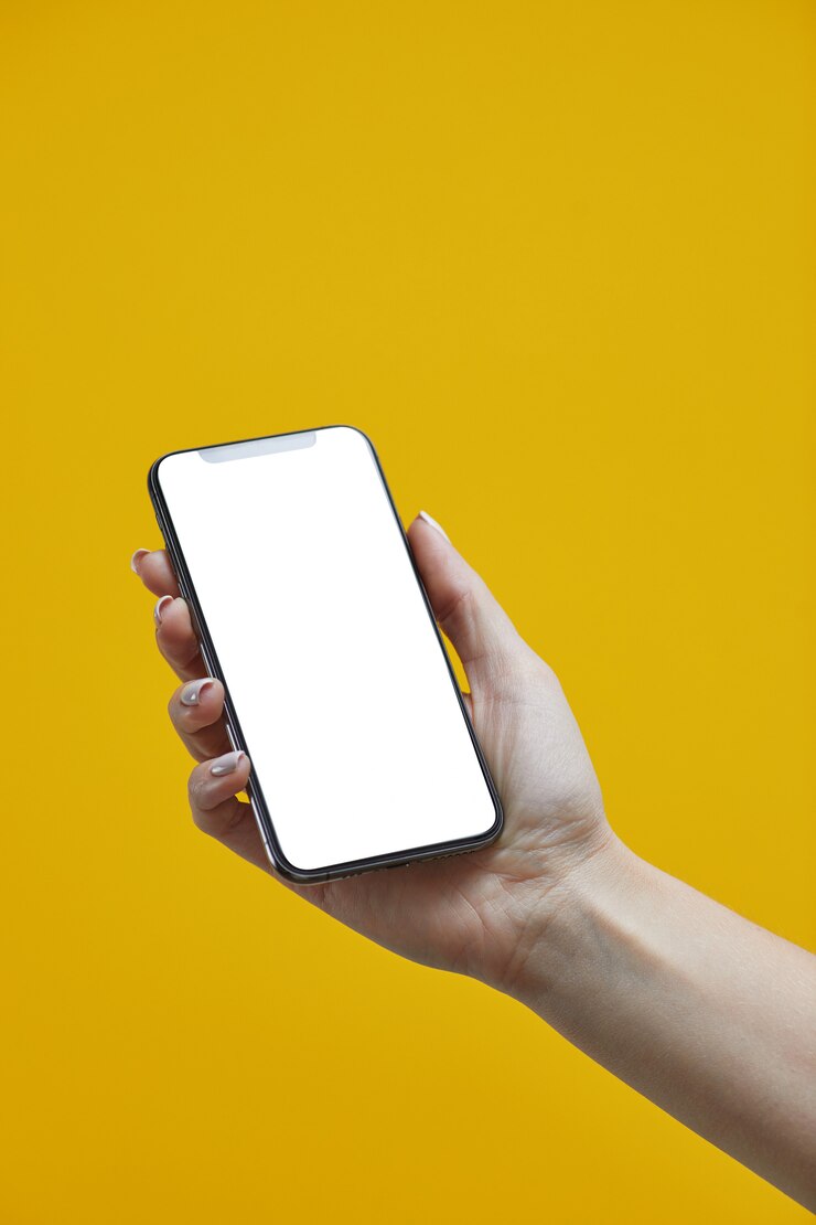 Vrouwenhand die mobiele smartphone met het witte scherm op geel houden.
