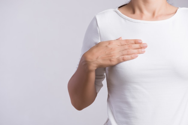 Vrouwenhand die stukken op haar borst controleren op tekens van borstkanker.