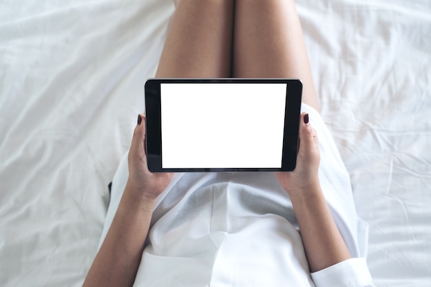 Vrouwenhand die tabletpc op het bed met behulp van