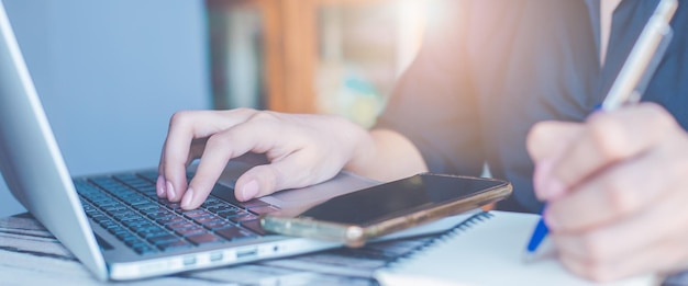 Vrouwenhand gebruikt een laptopcomputer op kantoor voor webbanner