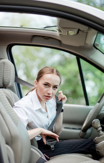 Vrouwenhand maakt de veiligheidsgordel van de auto vast Sluit uw autogordel terwijl u in de auto zit voordat u gaat rijden en maak een veilige reis Close-up shot van vrouwelijke bestuurder maakt veiligheidsgordel vast