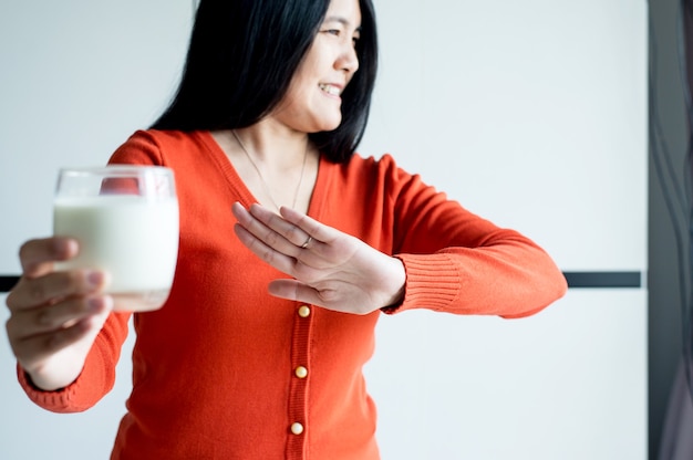 Vrouwenhanden die een glas melk weigeren, Vrouw met allergiemelk, Lactose-intolerantieconcept