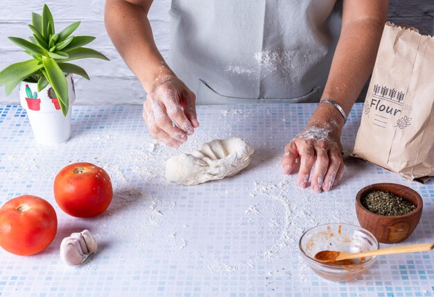 Vrouwenhanden die een meelkoek kneten