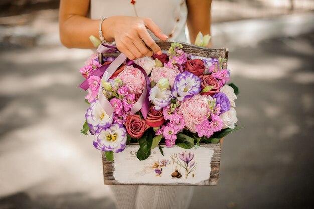 Vrouwenhanden die een mooie samenstelling van bloemen houden