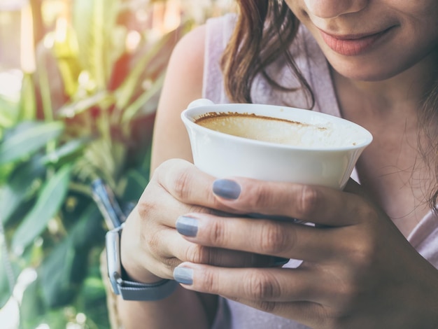 Vrouwenhanden die een wit hete koffiekop houden