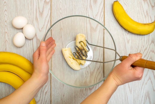 Vrouwenhanden die verschillende bananen pureren om in broodcupcakes te bakken chef-kok bereidt ingrediënten voor voor het maken van cottage cheese muffinscasserole thuis keuken keuken online kookrecept instructie