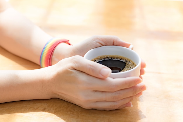 Vrouwenhanden die witte koffiekop houden