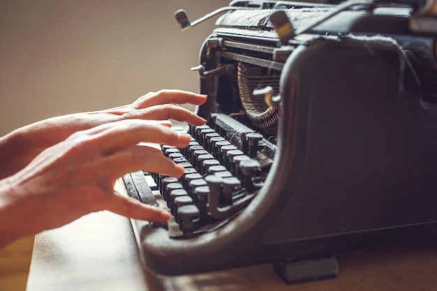 Vrouwenhanden typen op een oude vintage met stof beklede schrijfmachine