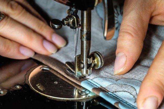 Vrouwenhanden van naaister met vintage naaimachine