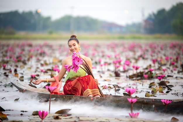 Vrouwenholding Lotus terwijl het Zitten op Boot in Meer