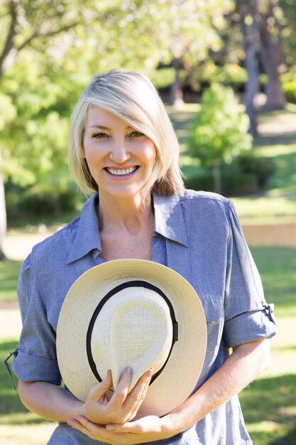 Vrouwenholding sunhat in park