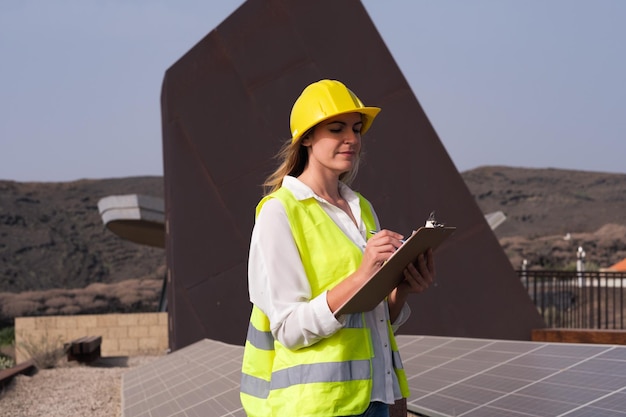 Vrouweningenieur die de zonnepanelen controleert