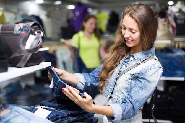 Vrouwenklant die jeans kiezen bij winkel