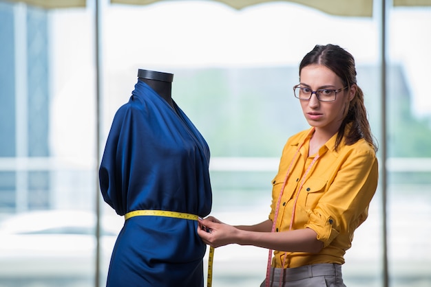 Vrouwenkleermaker die aan nieuwe kleding werken