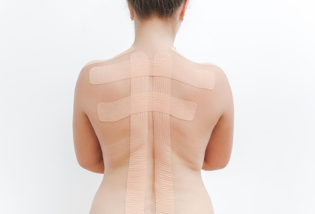 Vrouwenlichaam met kinesiotape op de rug Kinesiologie taping concept Witte achtergrond