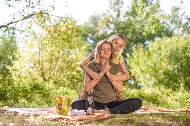 Vrouwenmasseuse voert adequaat een geweldige massage uit in de rustige buitenlucht.