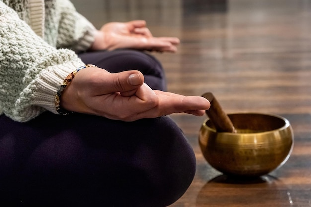 Vrouwenmeditatie met Tibetaanse klankschaal tijdens het beoefenen van yoga op mat