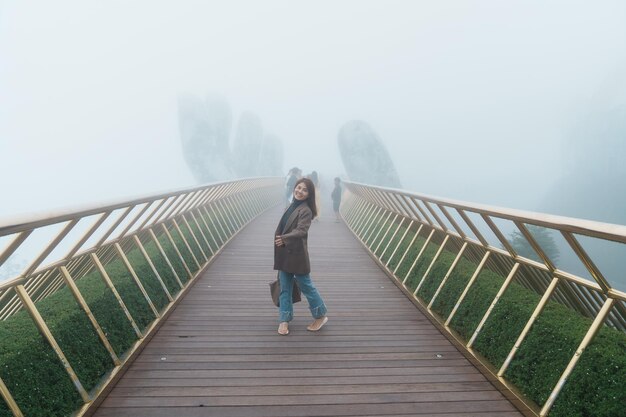 Vrouwenreiziger die de Gouden brug bezoekt op de top van het Ba Na Hills-oriëntatiepunt en het populaire reisconcept voor Vietnam en Zuidoost-Azië