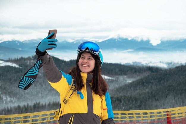 Vrouwenskiër die selfie op de telefoonbergen nemen op background