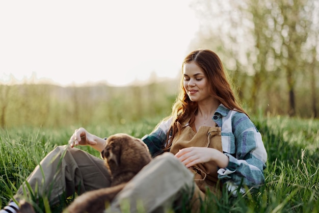 Vrouwenspel met haar hond in de natuur glimlachend en liggend op het groene gras in het park, gelukkig gezonde relatie tussen meesteres en huisdier