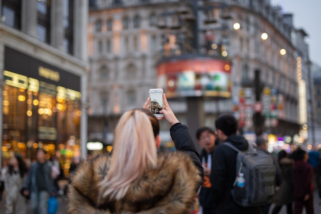 Vrouwentoerist die beelden van stad met haar celtelefoon nemen op straat