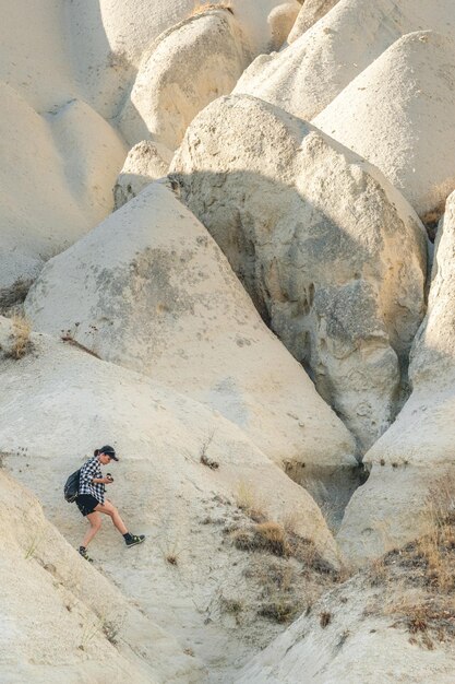 Vrouwentoerist die op zandsteenbergen in Cappadocië Turkije wandelen