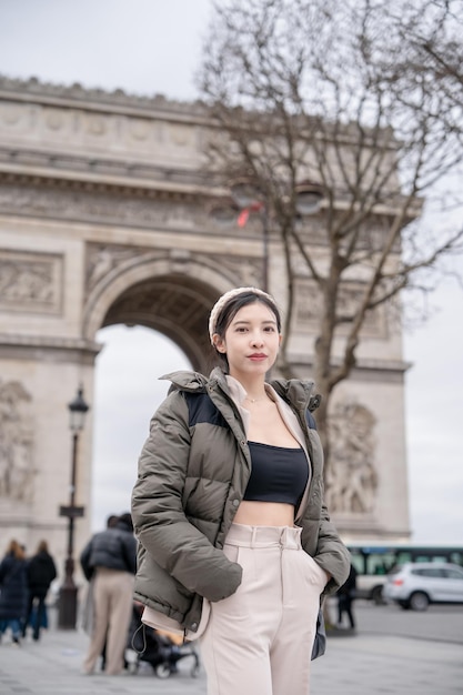 Vrouwentoerist op achtergrond van beroemde Arc de Triomphe Winter of herfst in Europa Parijs Frankrijk