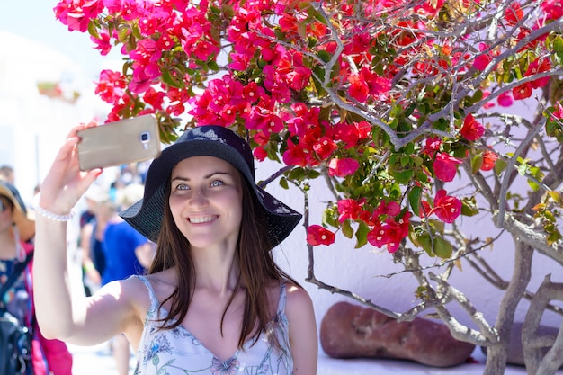 Vrouwentoerist op vakantie, die door de straten van Oia in eiland Santorini slenteren.