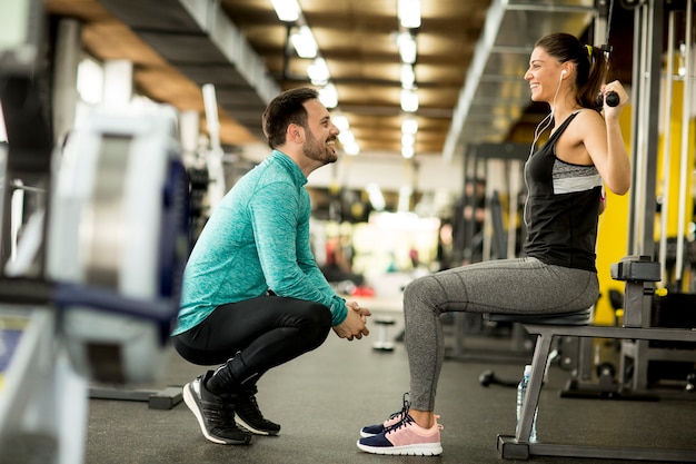 Vrouwentraining in een gymnastiek met behulp van haar persoonlijke trainer