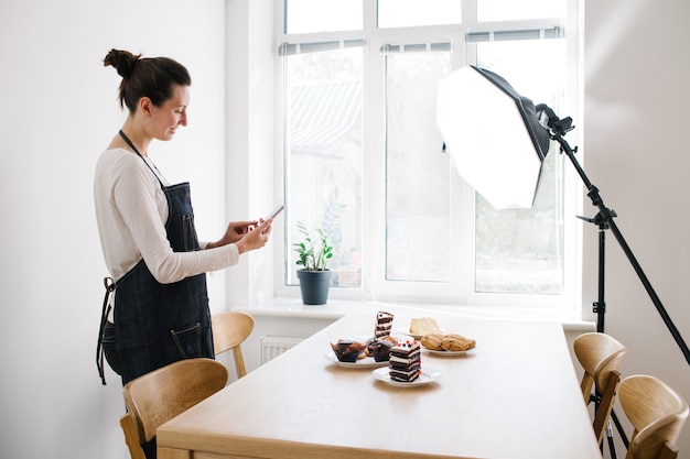 Vrouwenvlogger die video opneemt voor voedselkanaal. Cooker shef neemt een video op voor vlog met een telefoon