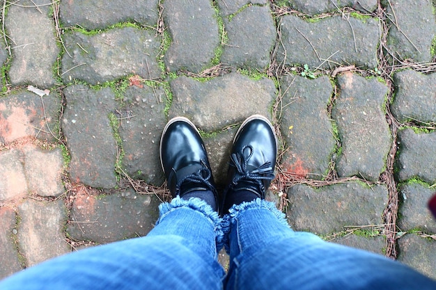 Vrouwenvoeten in schoenen die op rotsachtige weg lopen