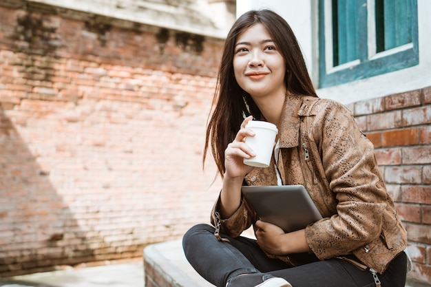 Vrouwenzitting en het genieten van van koffie terwijl openlucht werken