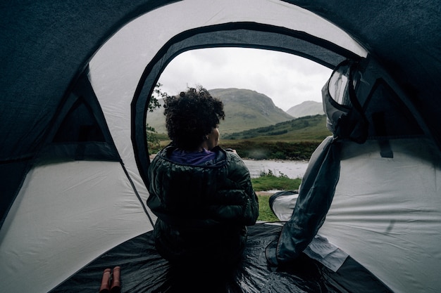 Vrouwenzitting in een tent terwijl het regent